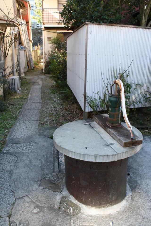 井戸の脇には細い路地が続く