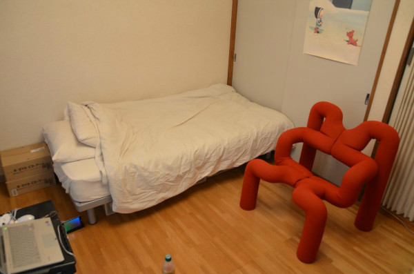 ベッドと芸術的な赤い椅子。